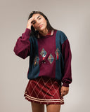 A woman wearing a maroon golf skirt with a checkered pattern and a matching top, posing against a neutral background.