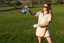 Woman holding a disco ball on a golf course