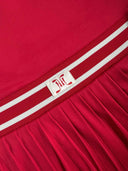 Red garment with a white label featuring a logo on a plain background