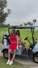 two girls in dresses in a golf cart