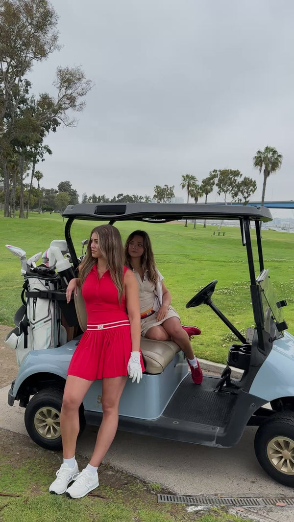 two girls in dresses in a golf cart
